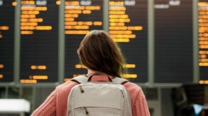 Mujer mirando una pantalla de información de vuelos del aeropuerto.