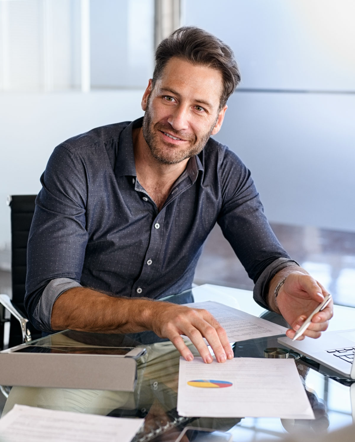Hombre sonriendo junto a papeles